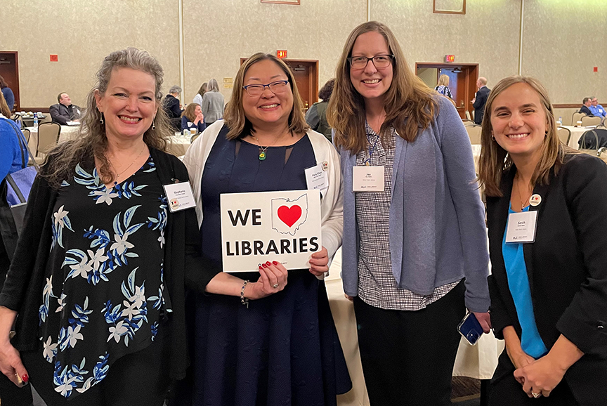 photo of library supporters with sign saying We Love Libraries