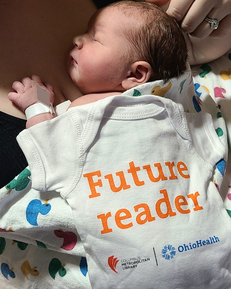 photo of newborn with library onesie