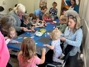 photo of families doing crafts around table at library