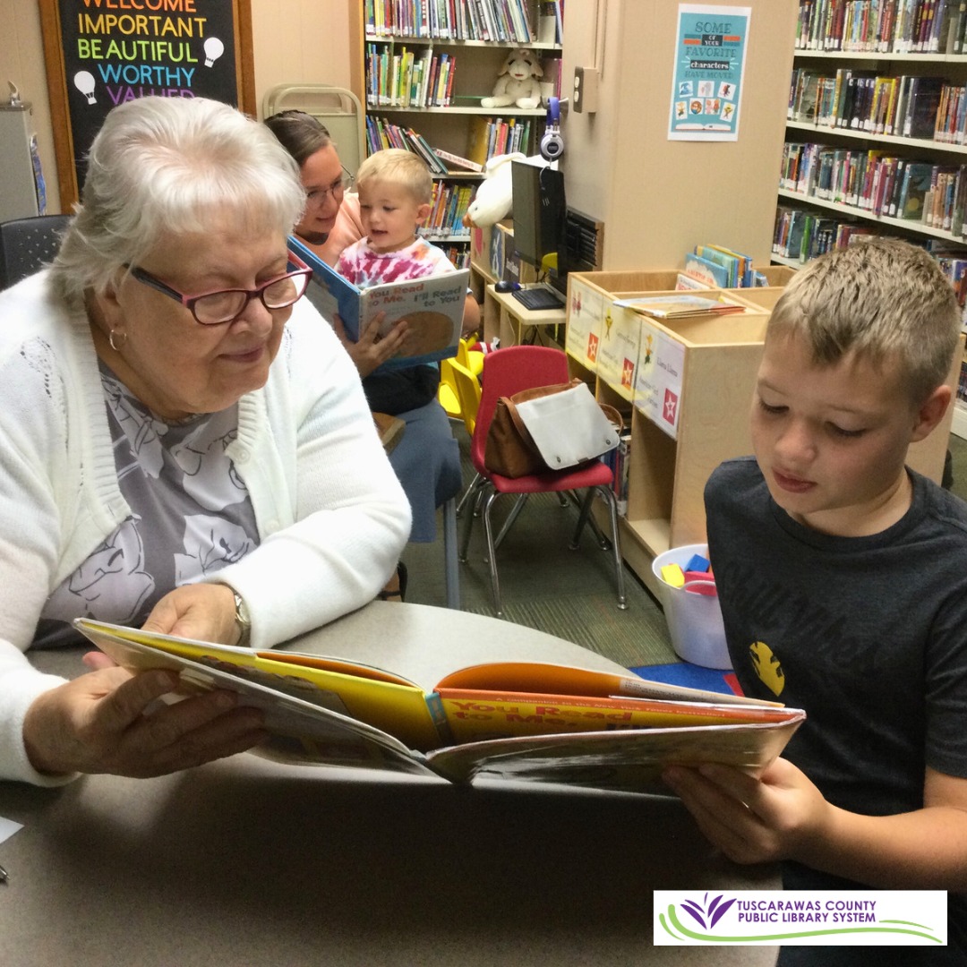 photo of senior reading with child at library