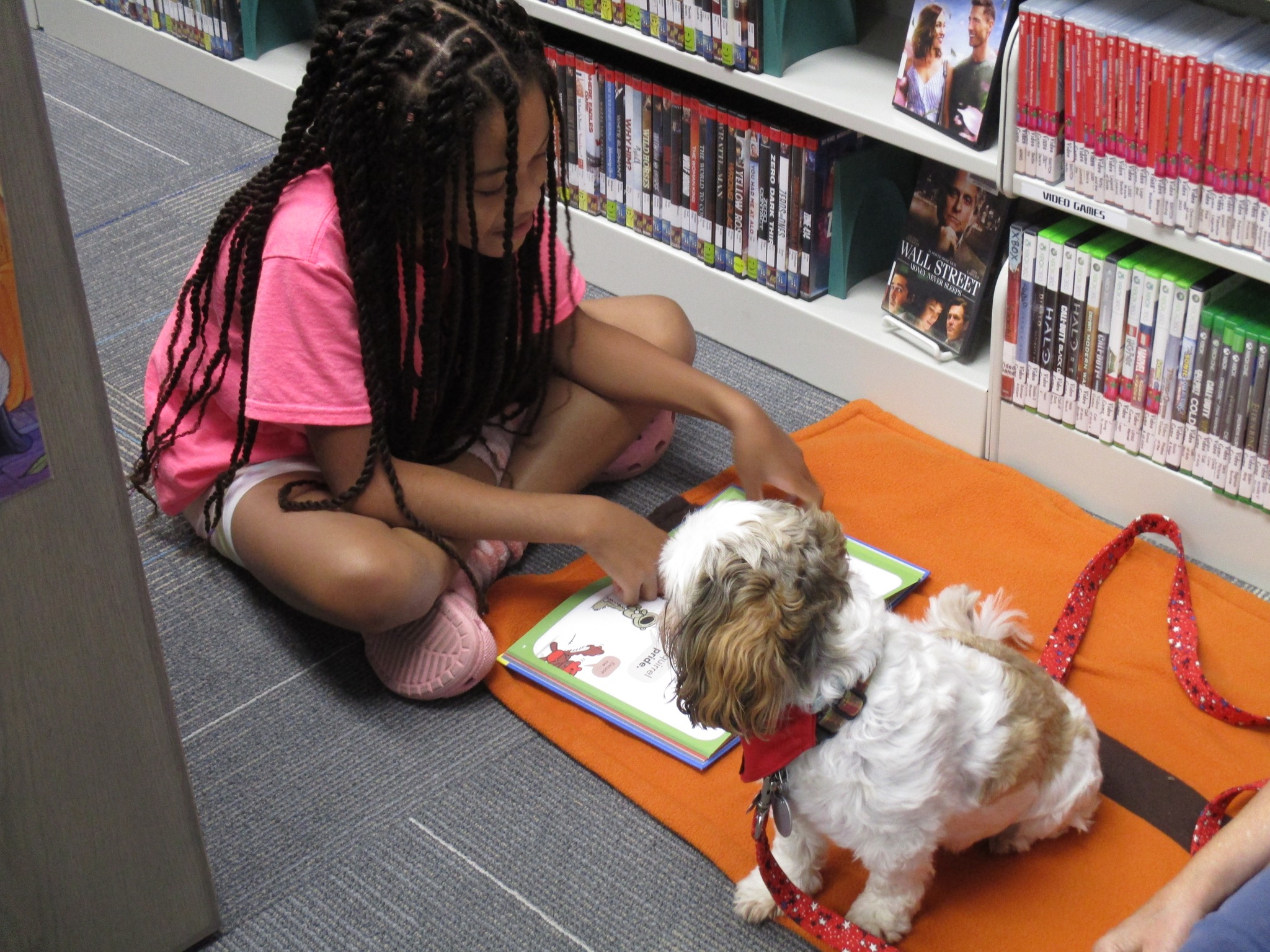 girl reading book to dog.