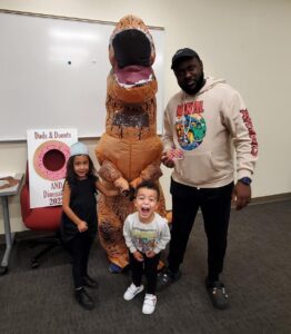 photo of dad and kids with inflatable dinosaur
