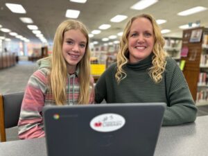 photo of mom and daughter using laptop and WiFi at library
