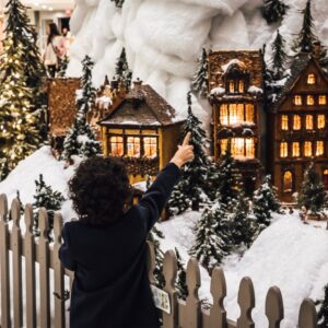 child points to holiday train display in library