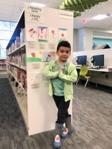 boy standing in front of library book case